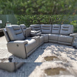 Load image into Gallery viewer, Gray sectional sofa outdoors on a gravel surface with greenery in the background
